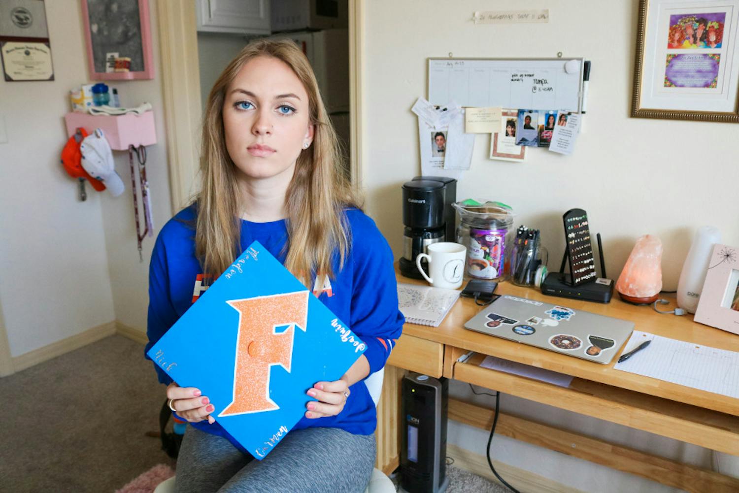 Elizabeth Stout, Parkland survivor and UF political science freshman, shows the cap she made for her graduation from Marjory Stoneman Douglas High School. Stout says she wants it to honor the four seniors that were unable to graduate due to the tragedy: Carmen Schentrup, Nicholas Dworet, Meadow Pollack and Joaquin Oliver.