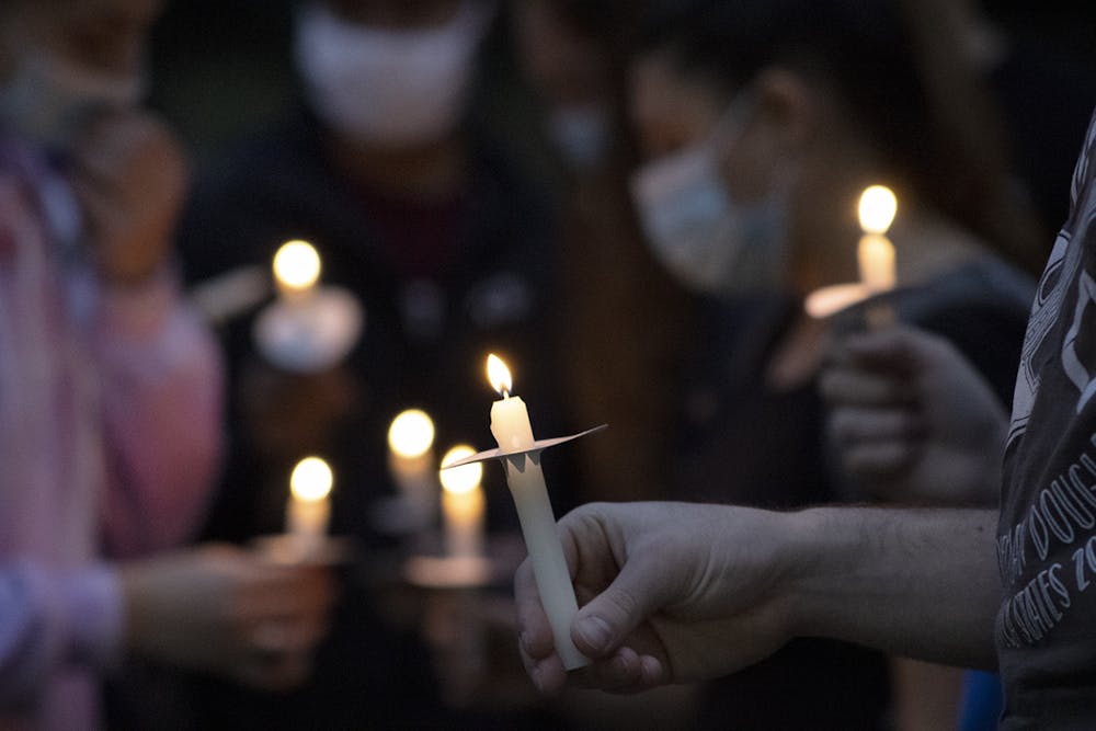 <p>About 80 people hold candles and gather during a vigil on Sunday, Feb. 14, 2021 for those killed in the Marjory Stoneman Douglas High School shooting three years ago.</p>