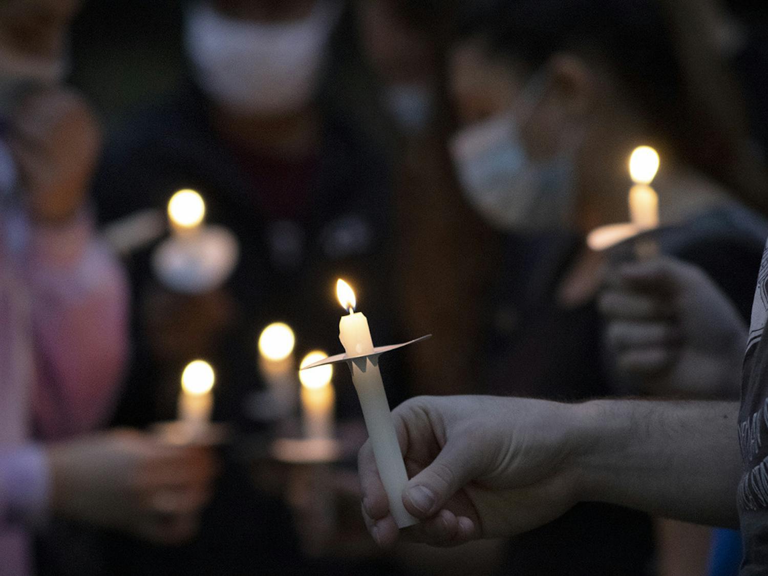 About 80 people hold candles and gather during a vigil on Sunday, Feb. 14, 2021 for those killed in the Marjory Stoneman Douglas High School shooting three years ago.
