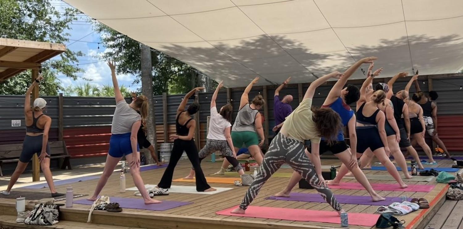 Patrons stretch at a First Magnitude Brewing Company drag yoga event on Sunday, June 23, 2024.