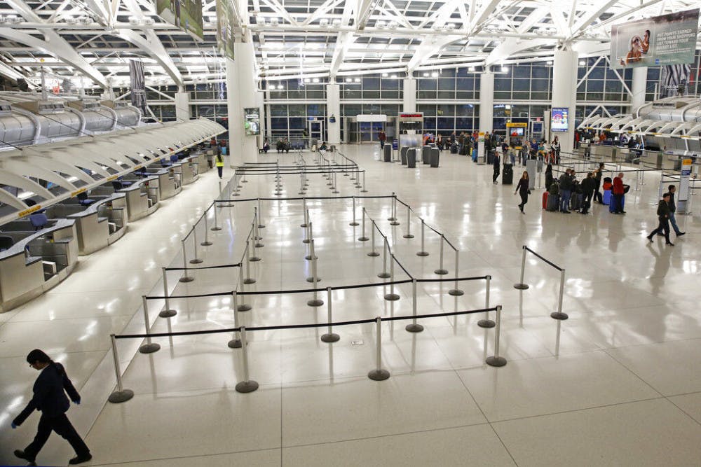People visit an international terminal at John F. Kennedy airport, Friday, March 13, 2020, in New York. A ban on travelers from most European countries begins at midnight Friday, and travelers returning from there will be screened. The ban is the latest calamity for a global travel industry already reeling from falling bookings and canceled reservations as people try to avoid contracting and spreading the coronavirus. (AP Photo/Kathy Willens)