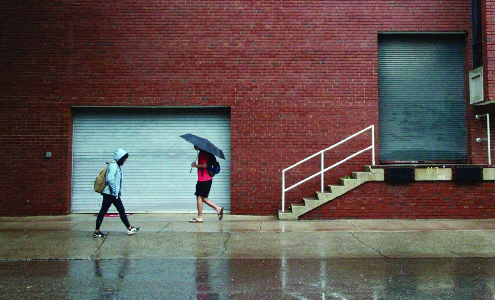 Students walk to class in rainy weather. 