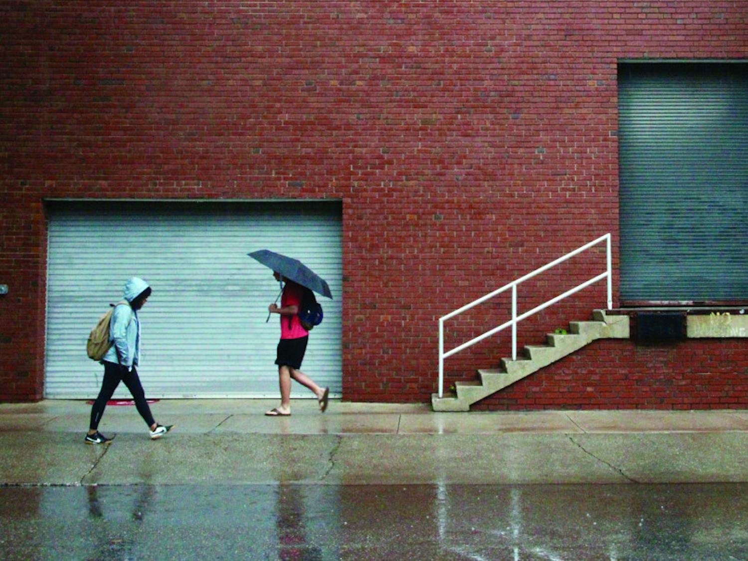 Students walk to class in rainy weather.