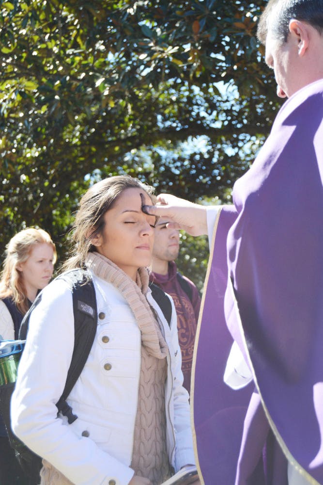 Valentina Osorio, a 21-year-old UF psychology senior, receives an ash cross from Father David Ruchinski of St. Augustine Church on Plaza of the Americas on Feb. 10, 2016 A crowd of about 200 gathered to observe Ash Wednesday, the day that marks the beginning of Lent.