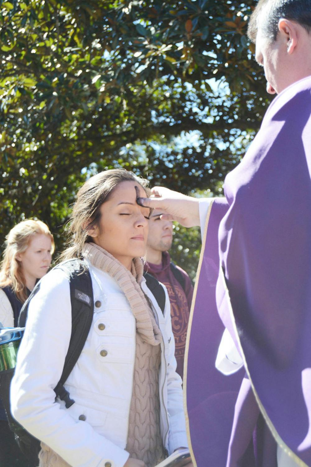 <p>Valentina Osorio, a 21-year-old UF psychology senior, receives an ash cross from Father David Ruchinski of St. Augustine Church on Plaza of the Americas on Feb. 10, 2016 A crowd of about 200 gathered to observe Ash Wednesday, the day that marks the beginning of Lent.</p>