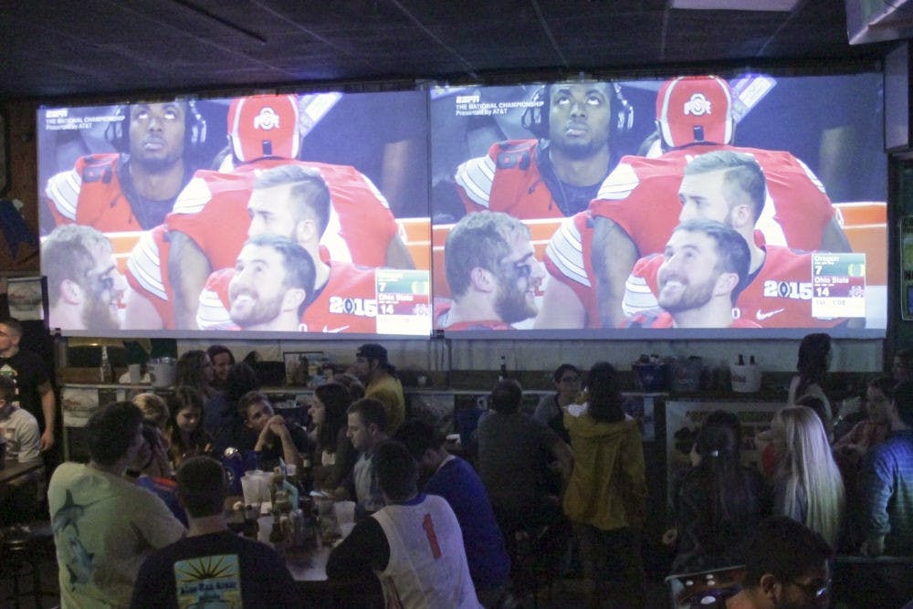 <p>A crowded bar watches the National Championship game between University of Oregon and Ohio State University in Mother’s Pub and Grill on West University Avenue on Monday night.</p>