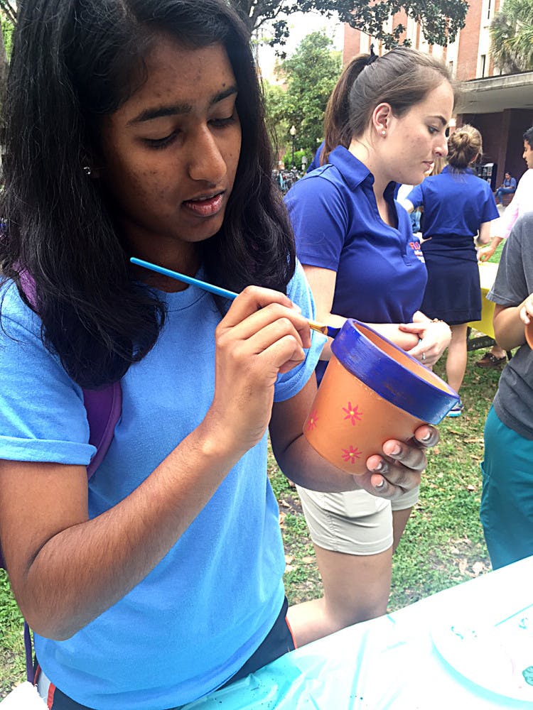 Anisha Patel, a 19-year-old UF finance freshman, paints a flower pot during Student Government’s Freshman Leadership Council’s Spring Forward, Look Back event on the Plaza of the Americas on Tuesday.