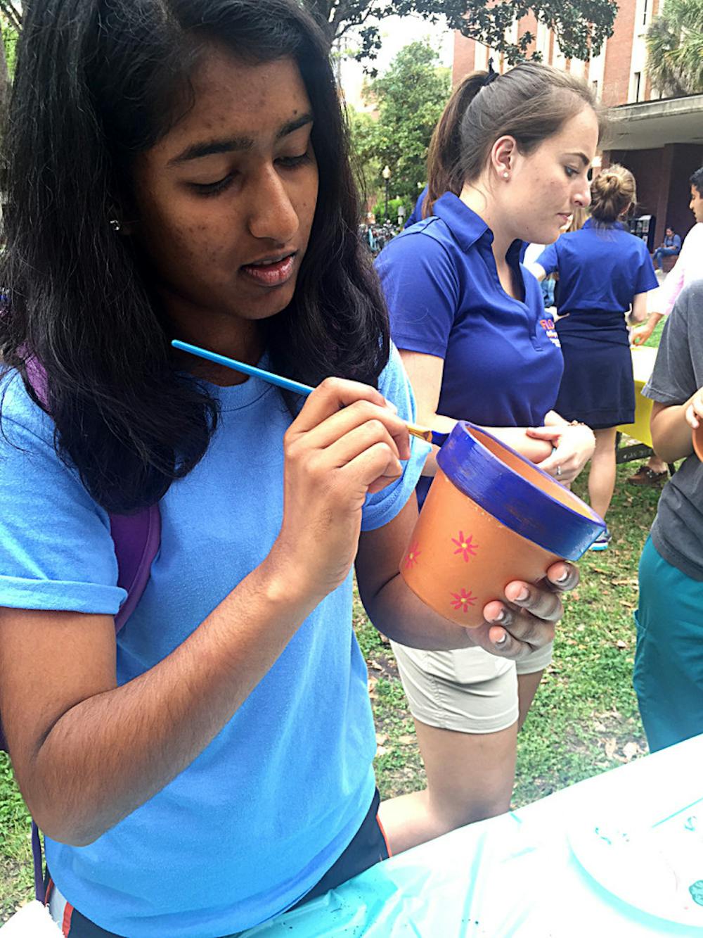 <p>Anisha Patel, a 19-year-old UF finance freshman, paints a flower pot during Student Government’s Freshman Leadership Council’s Spring Forward, Look Back event on the Plaza of the Americas on Tuesday.</p>