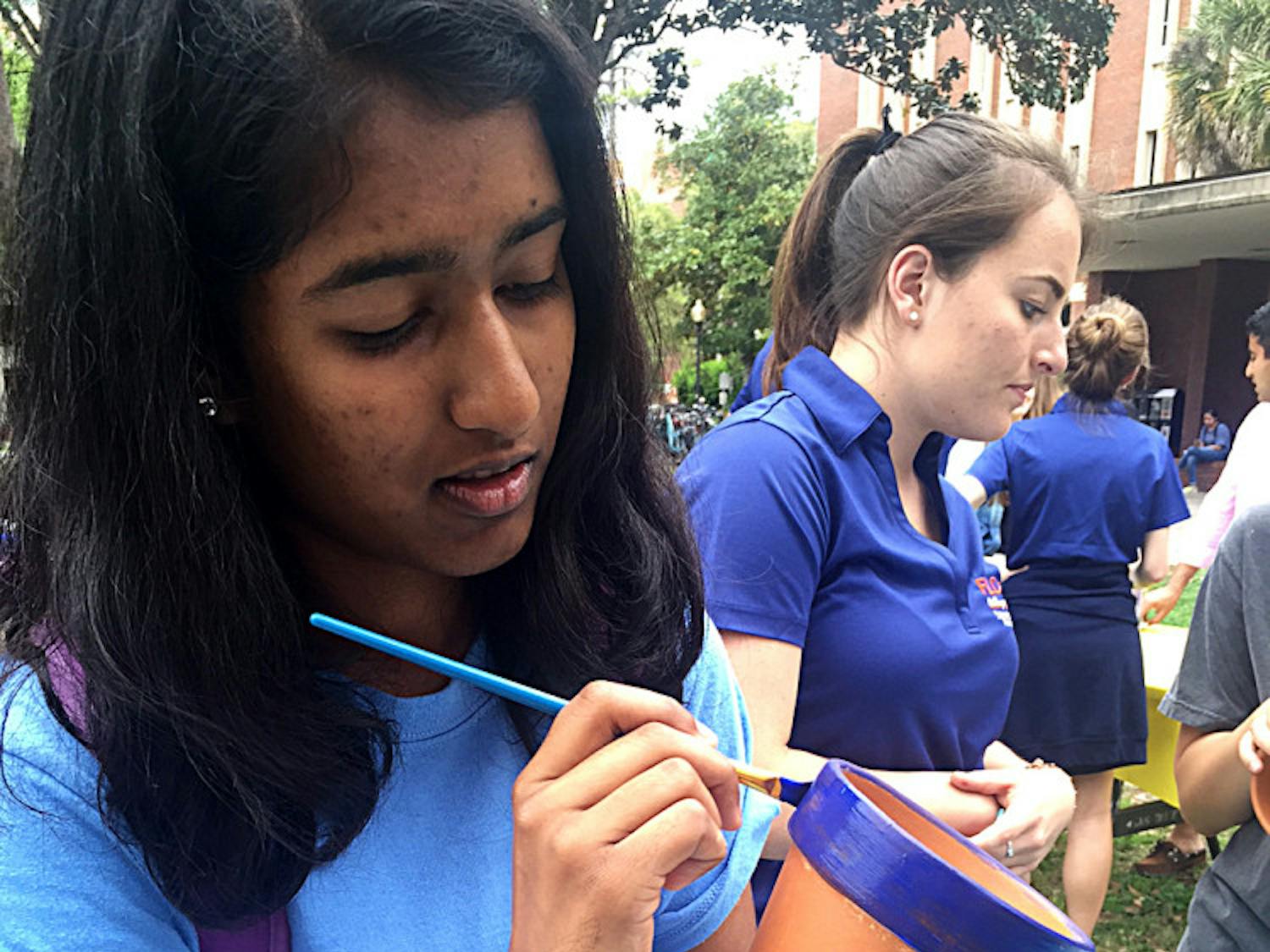 Anisha Patel, a 19-year-old UF finance freshman, paints a flower pot during Student Government’s Freshman Leadership Council’s Spring Forward, Look Back event on the Plaza of the Americas on Tuesday.