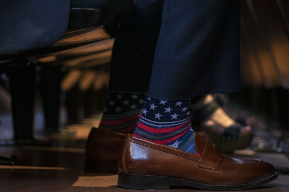 Senator Keith Perry wears socks with stars and stripes Thursday while waiting for Donald Trump Jr. to speak.