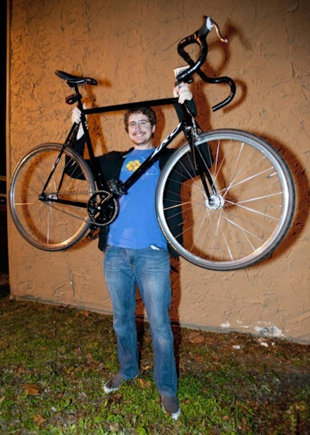 <p>Samuel B. Gause, 22, a chemistry graduate student, poses with his returned bike on Monday night.</p>