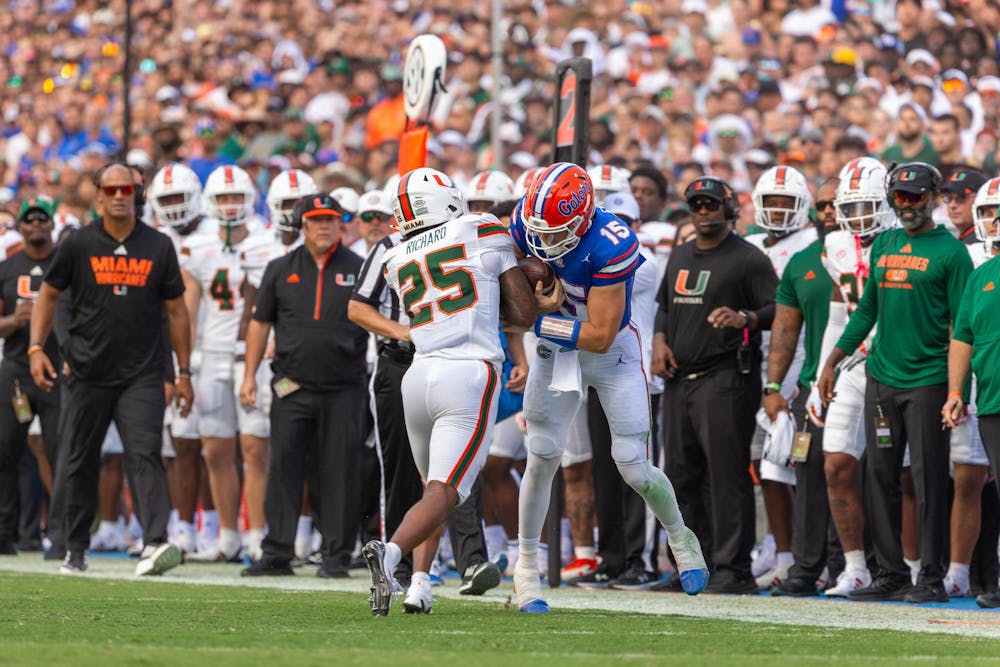 Florida Gators quarterback Graham Mertz hits Miami Hurricanes defensive back Chris Wheatley-Humphrey at the end of his run on Saturday, Aug. 31, 2024.

