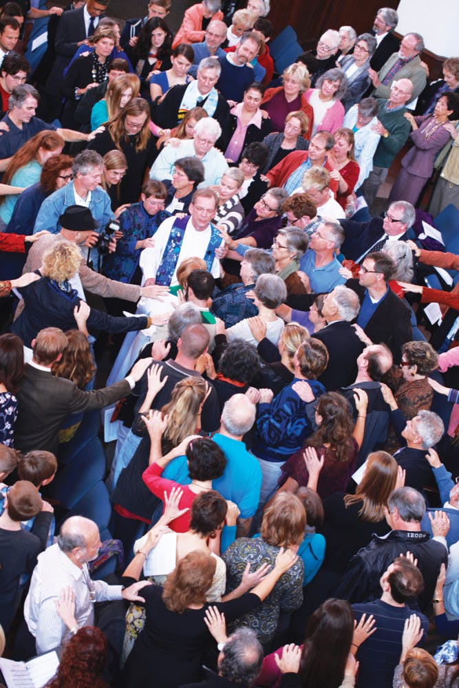 After about 40 years of service, worshippers join hands and say farewell to the Rev. Lawrence Reimer and the Rev. Sandy Reimer, both 68, at University Auditorium.