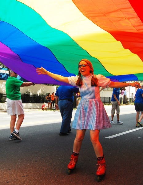 Julie Anspach, 56, dressed as Dorothy, rolls under a rainbow flag during the Gainesville Pride Festival and Parade on Saturday. The flag was held by church members of the United Church of Gainesville, who accept the LGBT community.