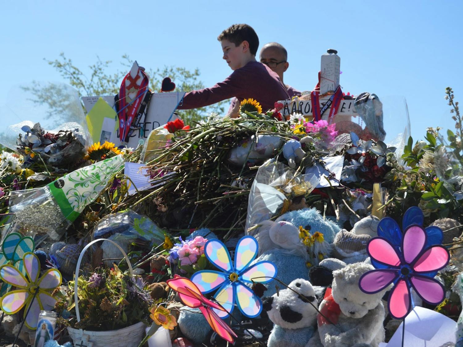 A young boy lays down a flower at the victim’s memorials outside Marjory Stoneman Douglas High School on March 3.