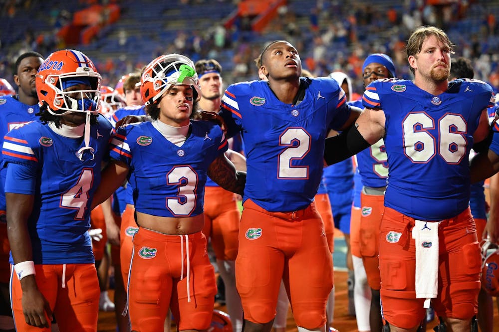 Florida Gators wide receiver TJ Abrams (4), wide receiver Eugene Wilson III (3), quarterback DJ Lagway (2) and offensive lineman Jake Slaughter (66) link arms during the alma mater in front of the band and student section after a loss in a football game between the South Florida Bulls and the Florida Gators on Sept. 6, 2025, at Ben Hill Griffin Stadium in Gainesville, Fla.