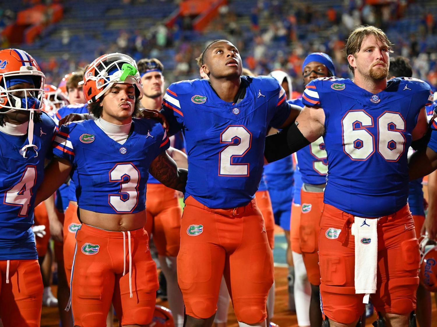 Florida Gators wide receiver TJ Abrams (4), wide receiver Eugene Wilson III (3), quarterback DJ Lagway (2) and offensive lineman Jake Slaughter (66) link arms during the alma mater in front of the band and student section after a loss in a football game between the South Florida Bulls and the Florida Gators on Sept. 6, 2025, at Ben Hill Griffin Stadium in Gainesville, Fla.