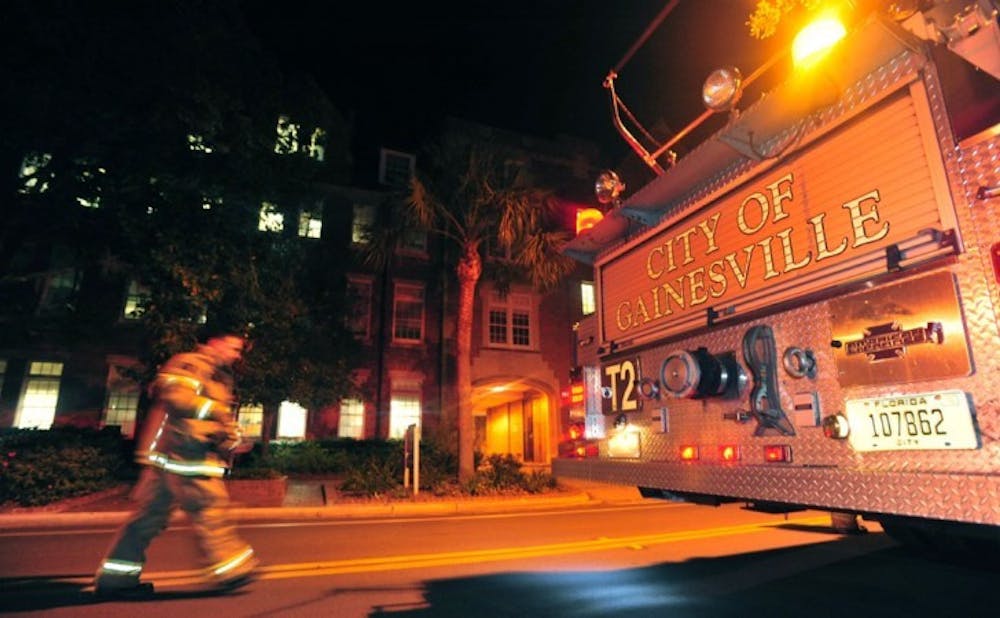 <p>A Gainesville Fire Rescue worker walks in front of Leigh Hall on Thursday evening.&nbsp; A small chemical spill was reported on the third floor of Sisler Hall.</p>