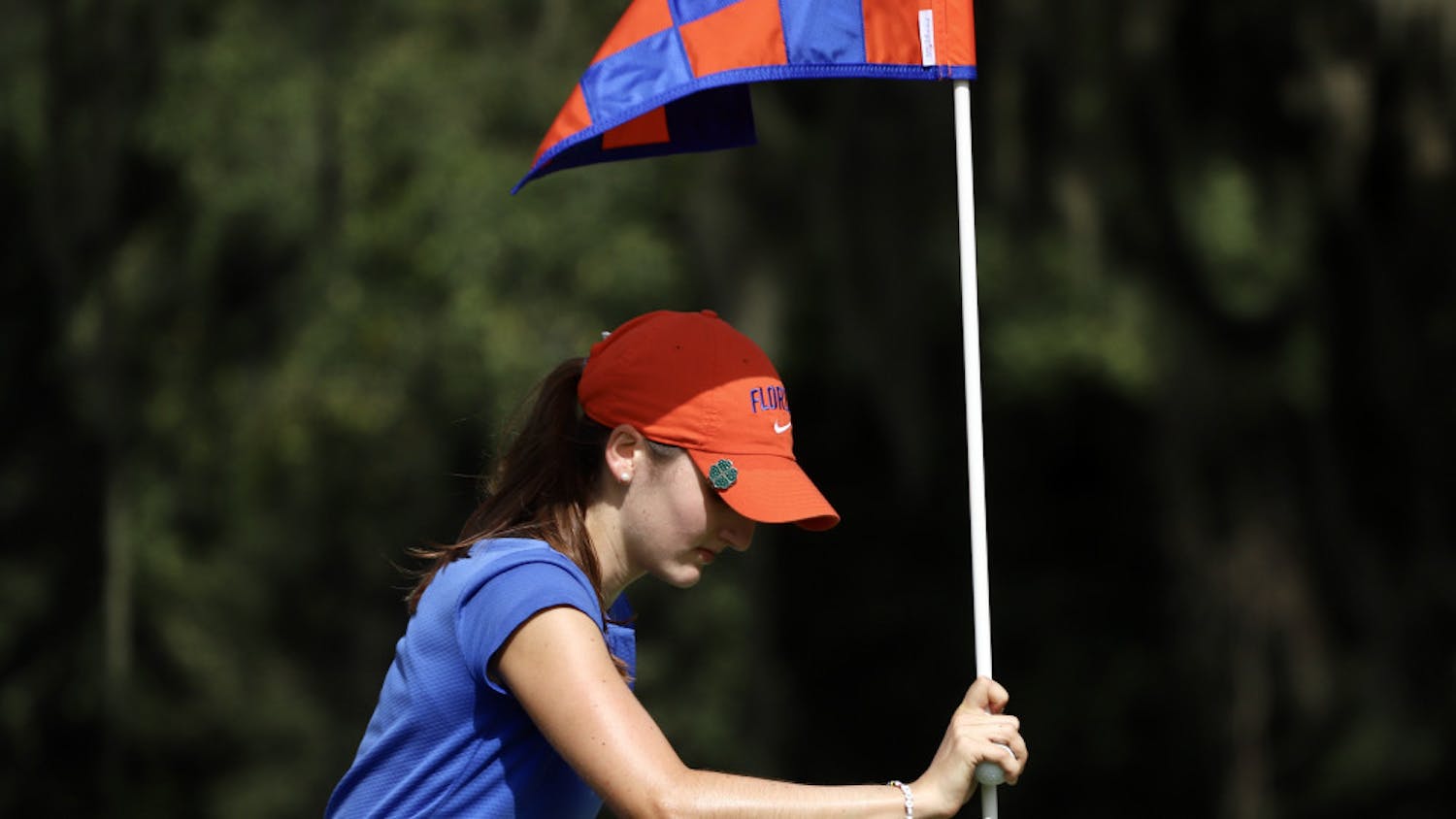 Junior Maisie Filler adjusts a flag at Mark Bostick Golf Course.