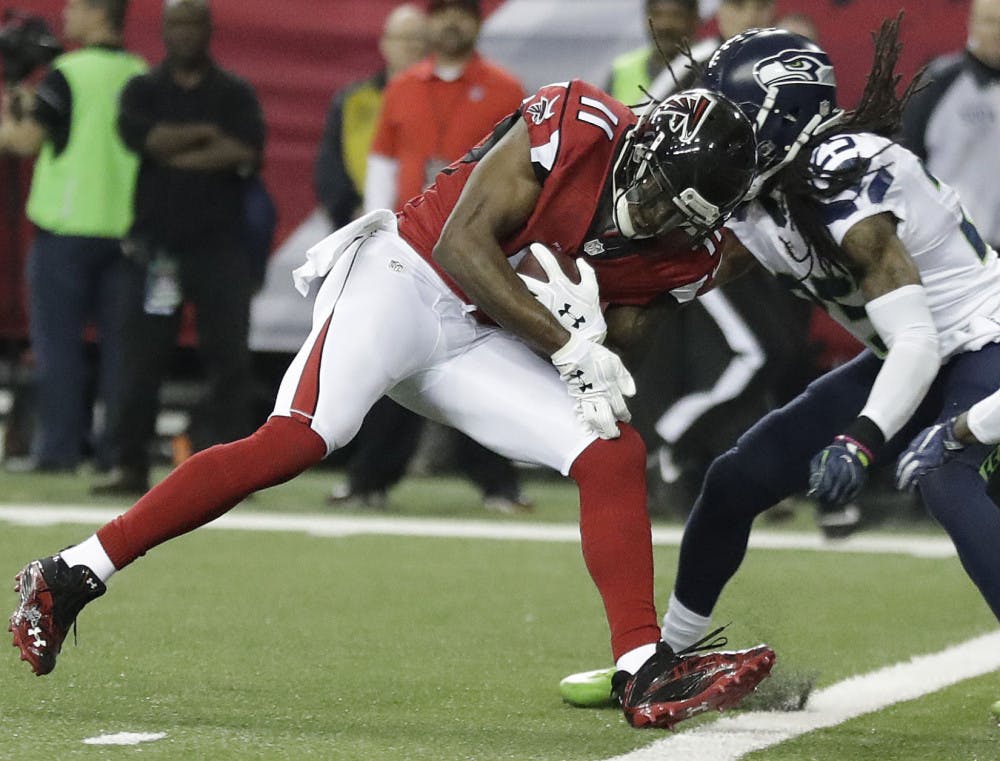 Atlanta Falcons wide receiver Julio Jones (11) runs into Seattle Seahawks cornerback Richard Sherman (25) as Jones scores a touchdown during the first half of an NFL football NFC divisional playoff game, Saturday, Jan. 14, 2017, in Atlanta. (AP Photo/David Goldman)
