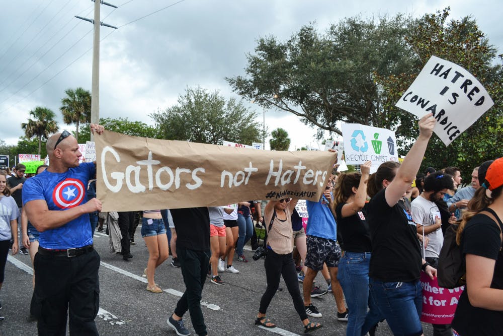 <p><span id="docs-internal-guid-e9f0ff65-389b-5594-e0d9-a0dbe99a9e88"><span>Richard Spencer protesters march toward the Phillips Center for the Performing Arts holding a “Gators not Haters” sign.</span></span></p>