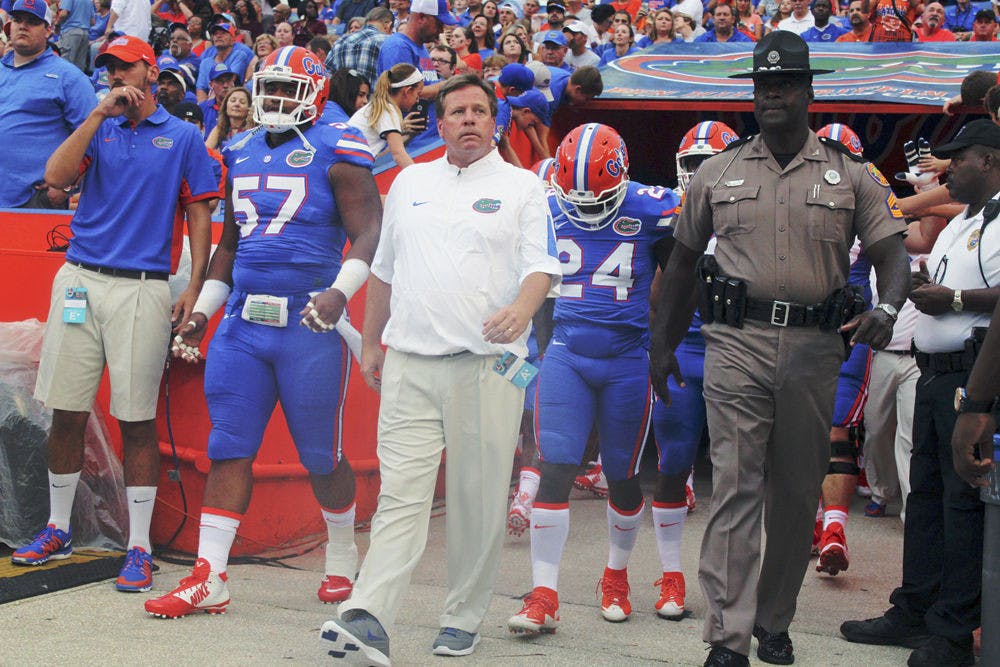 <p>UF football coach Jim McElwain walks out of the tunnel Florida's 61-13 win against New Mexico State on Saturday at Ben Hill Griffin Stadium.</p>
