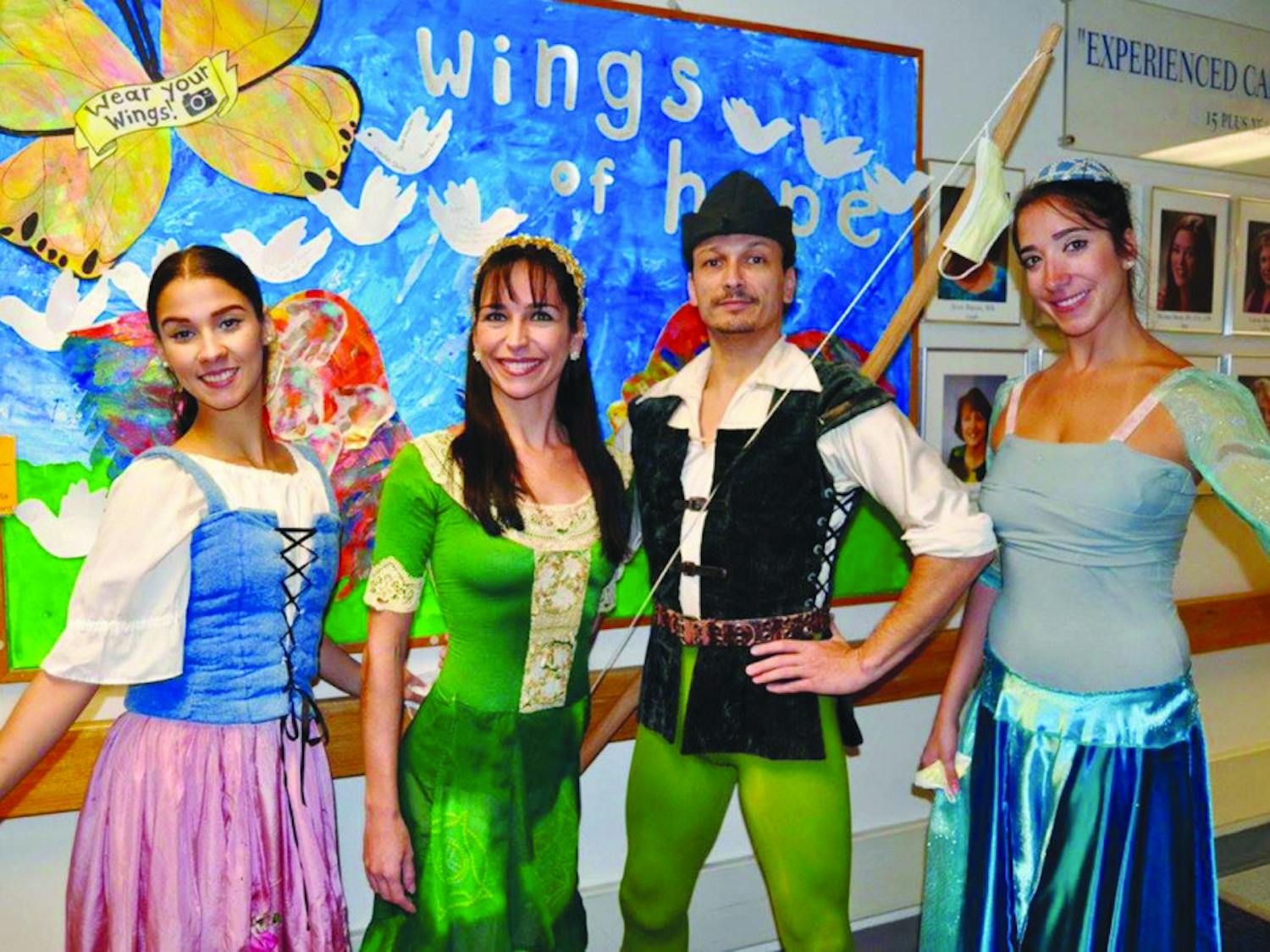 Beatriz Pereira Póvoas, Carla Amancio, Andre Valladon and Bárbara Várady pose while visiting  UF Health Shands Hospital’s pediatric cancer center. The members of the Gainesville dance troupe Dance Alive National Ballet were visiting sick children and promoting their show, “Robin Hood,” on Friday.