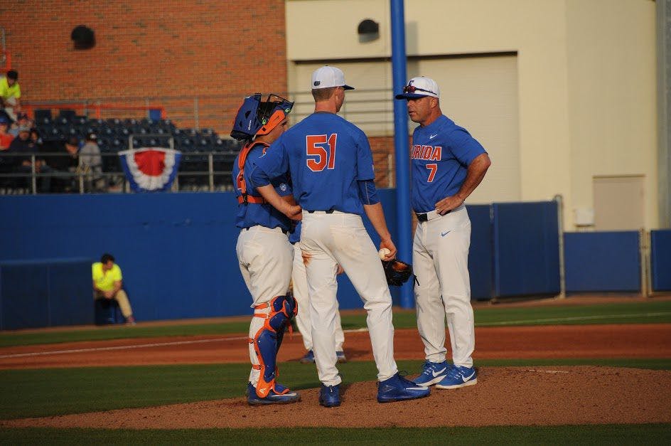 UF head coach Kevin O'Sullivan speaks with pitcher Brady Singer and catcher Mike Rivera during Florida's 8-1 win against William &amp; Mary on Feb. 18, 2017, at McKethan Stadium.&nbsp;