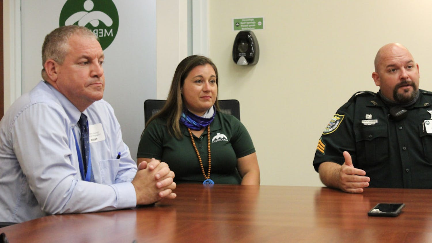 Sgt. Paul Pardue, supervisor of ACSO’s co-responder program (right), explains how Briana Kelley (middle) and Dan Maynard (left) will respond to mental health crises. Kelley is a mental health clinic specialist and Maynard is an ACSO deputy trained in crisis intervention.