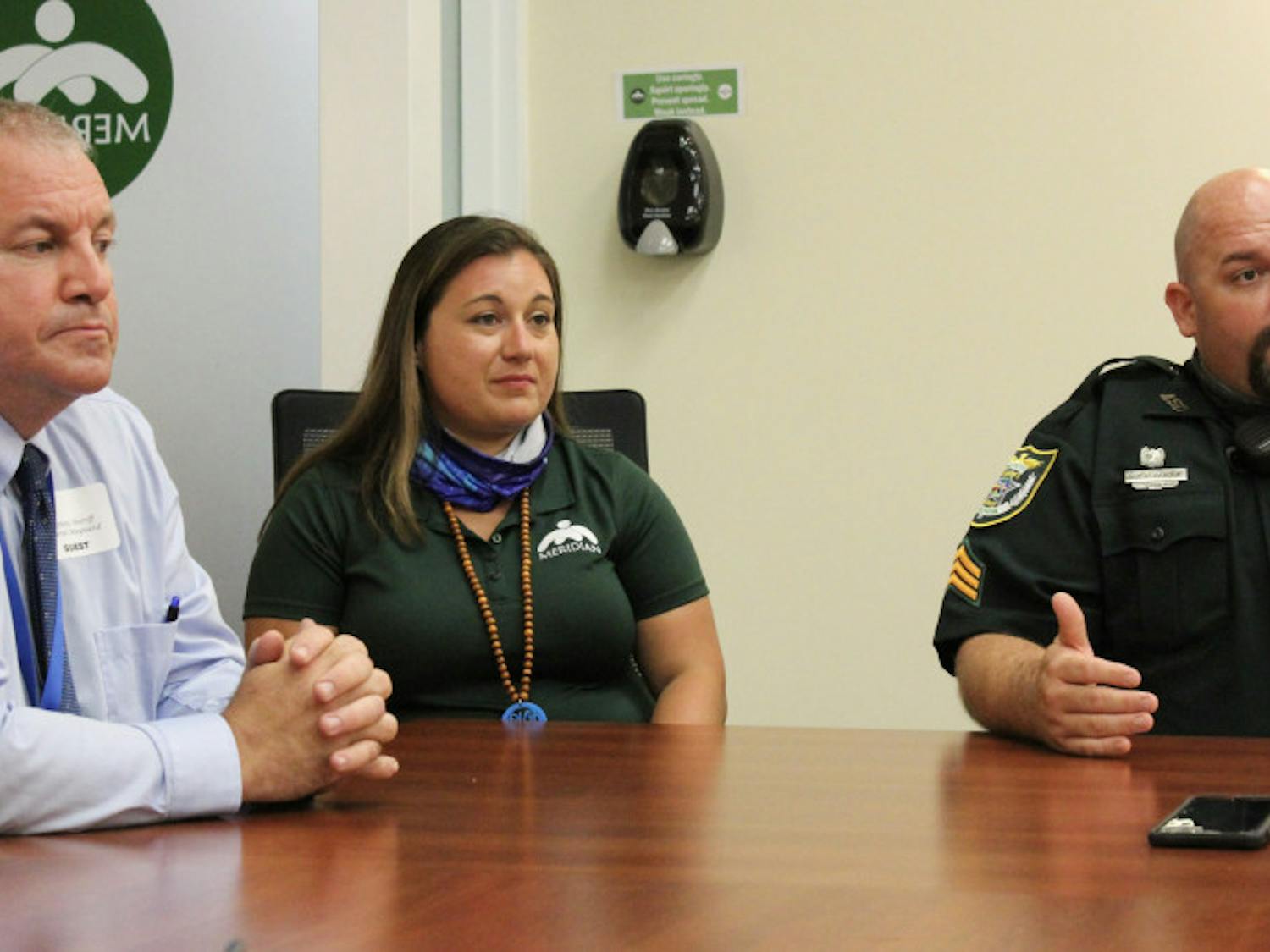 Sgt. Paul Pardue, supervisor of ACSO’s co-responder program (right), explains how Briana Kelley (middle) and Dan Maynard (left) will respond to mental health crises. Kelley is a mental health clinic specialist and Maynard is an ACSO deputy trained in crisis intervention.