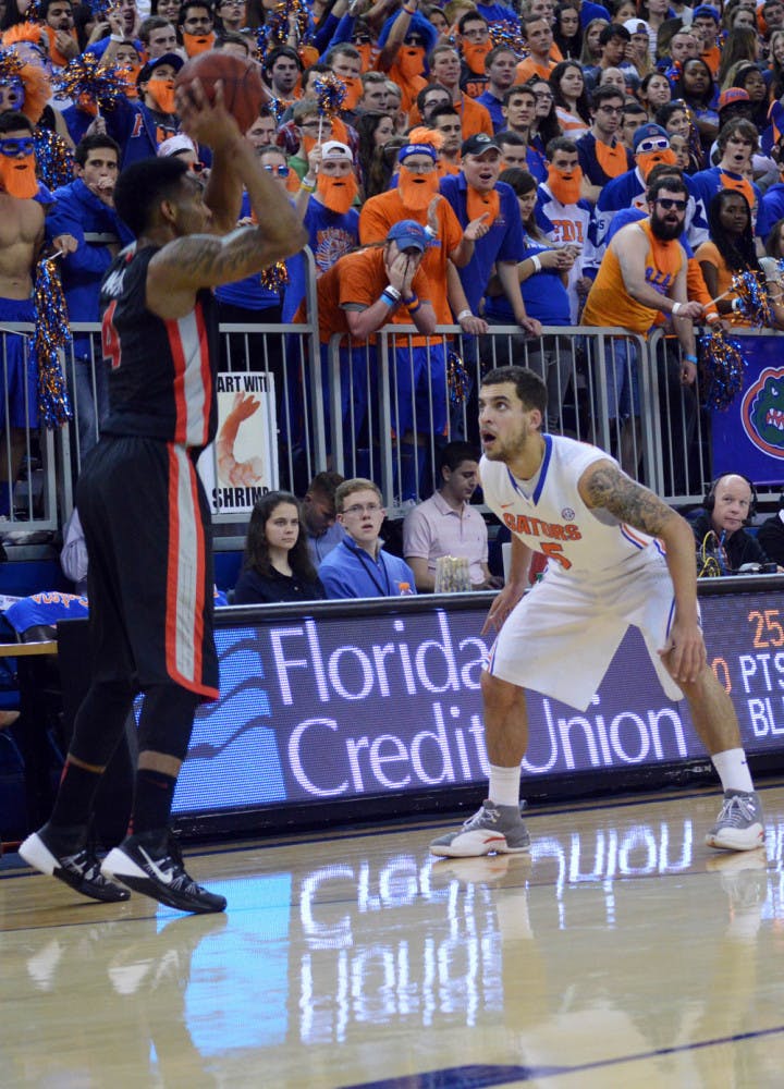 Scottie Wilbekin covers Georgia’s Charles Mann (4) during the Gators’ 72-50 win against the Bulldogs in the O’Connell Center on Tuesday.