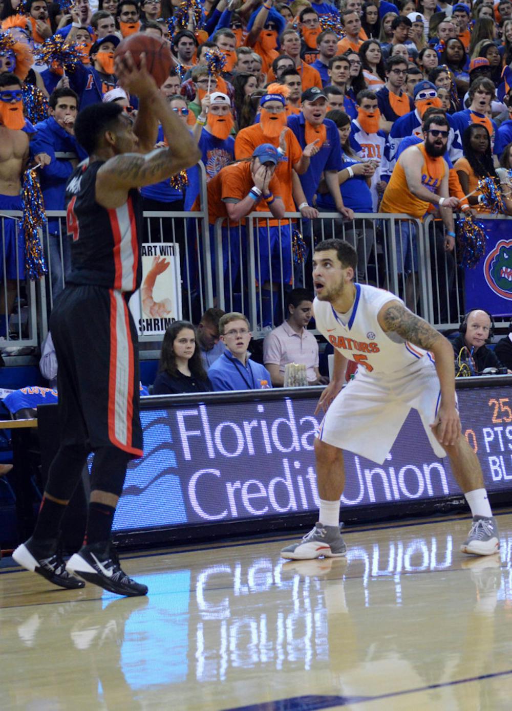 <p>Scottie Wilbekin covers Georgia’s Charles Mann (4) during the Gators’ 72-50 win against the Bulldogs in the O’Connell Center on Tuesday.</p>