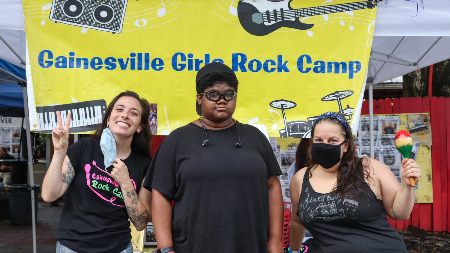 (Left to right) Coral Smith, Charlotte Katz Howick and Jennifer Vito stood in front of the information booth on Saturday. Howick was a previous camper of Gainesville Girls Rock Camp.