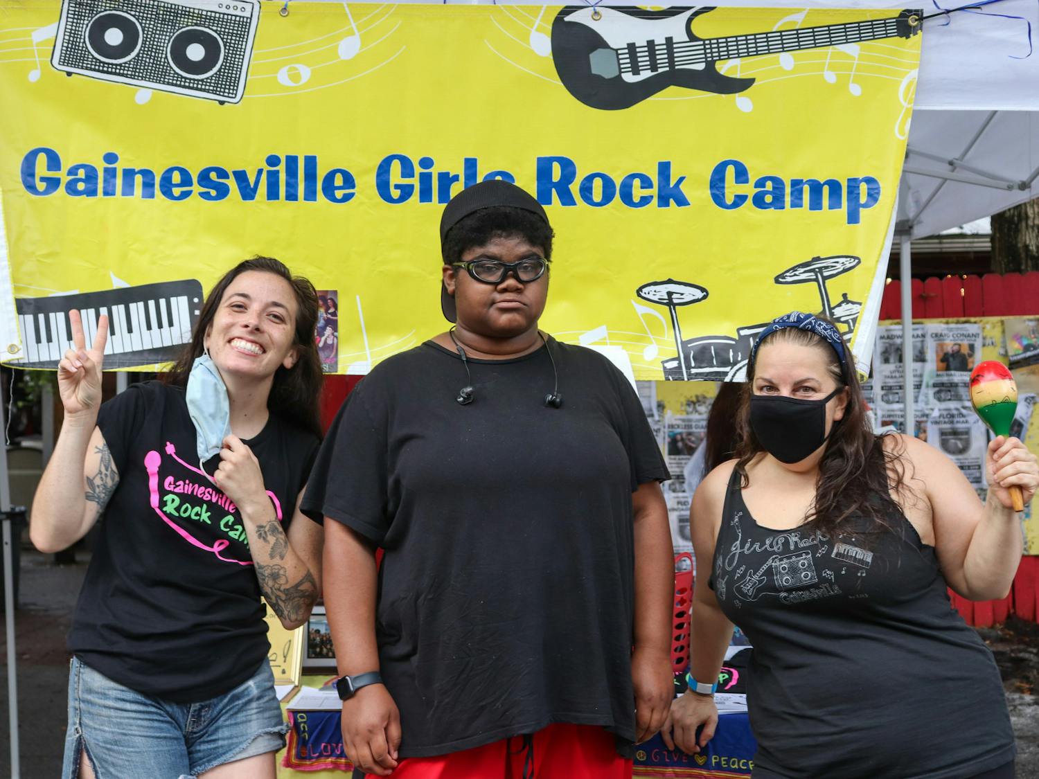 (Left to right) Coral Smith, Charlotte Katz Howick and Jennifer Vito stood in front of the information booth on Saturday. Howick was a previous camper of Gainesville Girls Rock Camp.