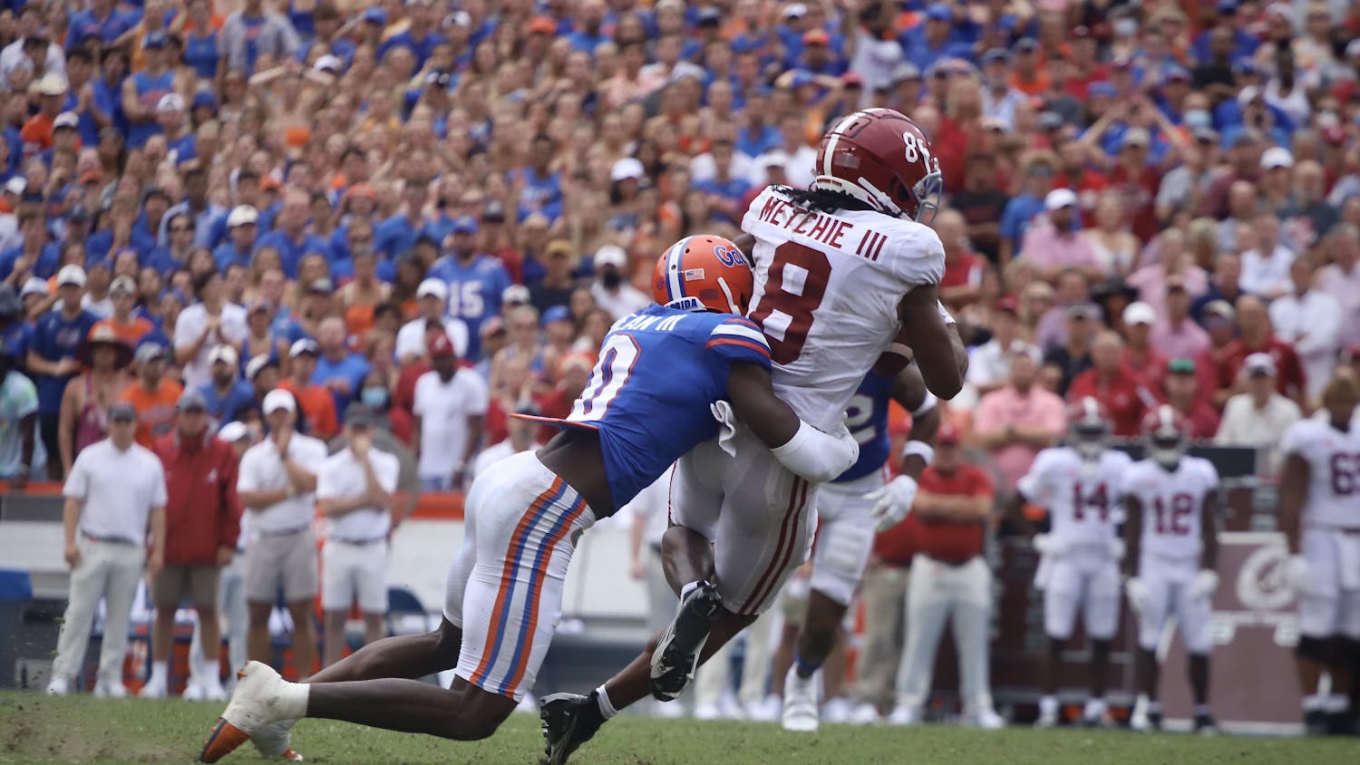 Safety Trey Dean III, pictured in blue, tackles Alabama wide receiver John Metchie III after he makes a catch. 