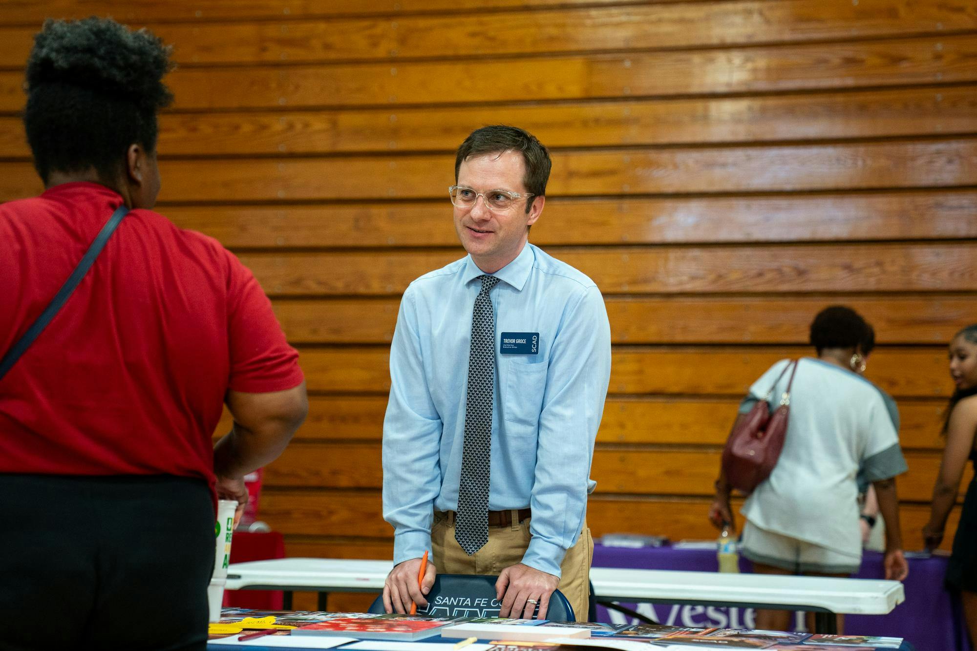 Trevor Groce of the Savannah College of Art and Design talks with an attendee during a college fair, Monday, Aug 31, 2026,  at Santa Fe College in Gainesville, Fla.