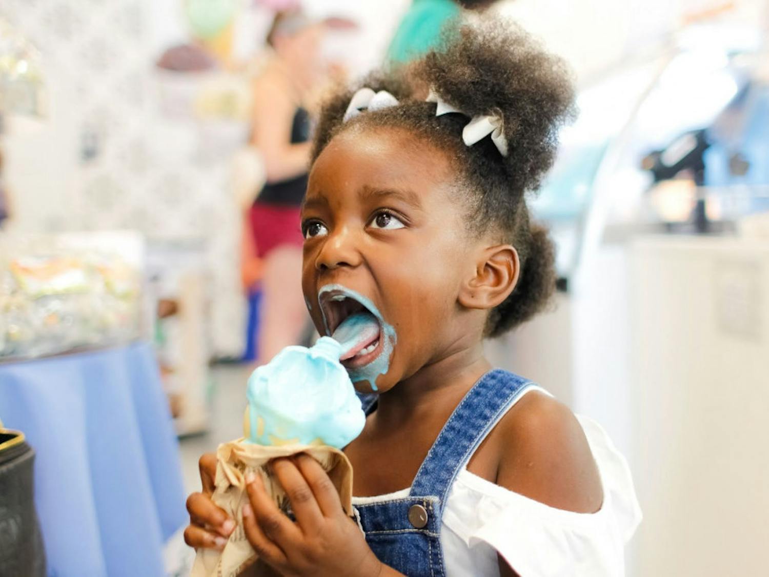 A young girl, Ava Coleman, enjoys her “blue moon" ice cream at Kilwin's Grand Opening. As part of their event, Gainesville's new Kilwin's hosted a raffle with prizes worth up to $100.