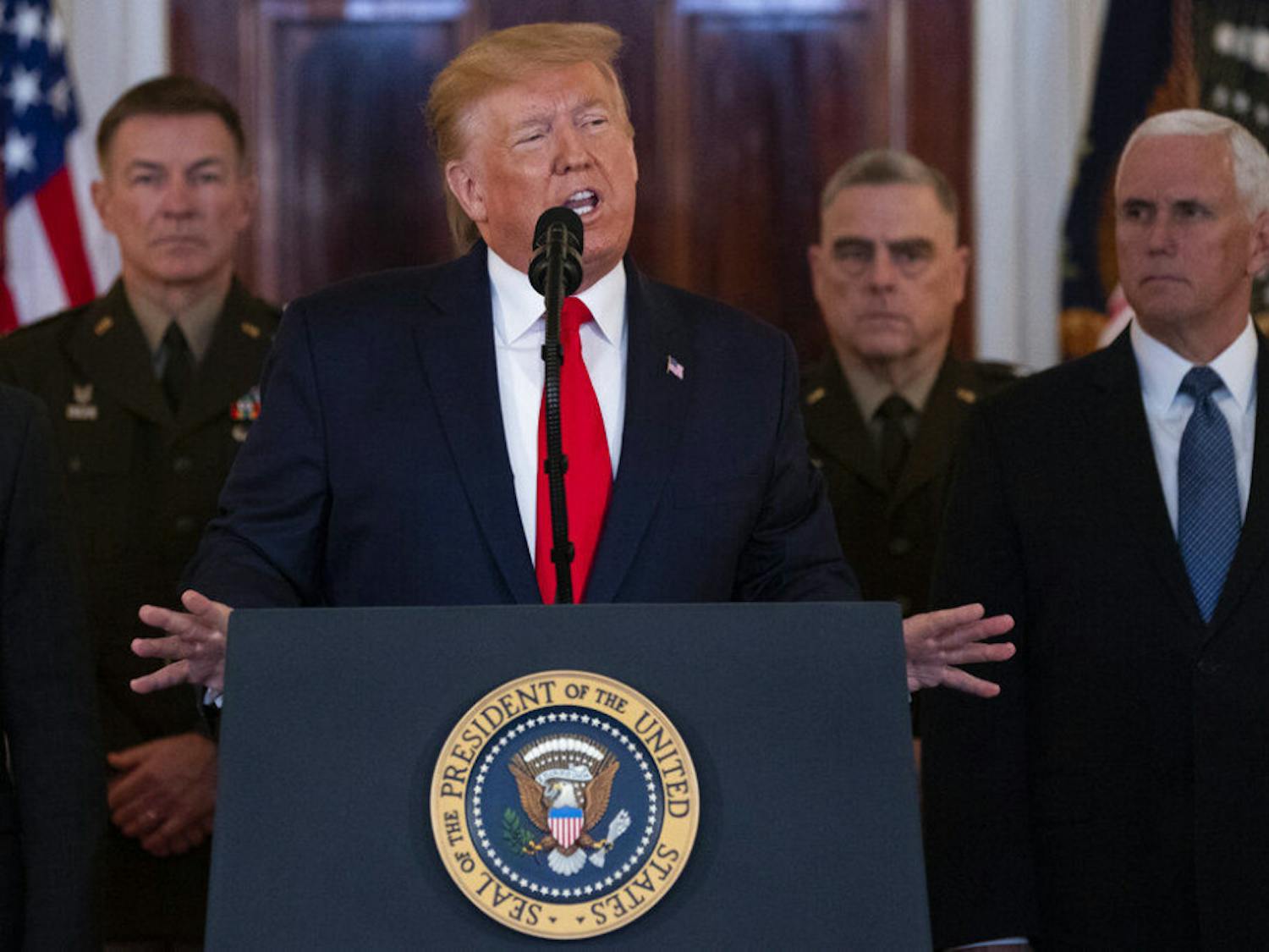 President Donald Trump addresses the nation from the White House on the ballistic missile strike that Iran launched against Iraqi air bases housing U.S. troops, Wednesday, Jan. 8, 2020, in Washington, as Chairman of the Joint Chiefs of Staff Gen. Mark Milley, Vice President Mike Pence, and others look on. (AP Photo/ Evan Vucci)