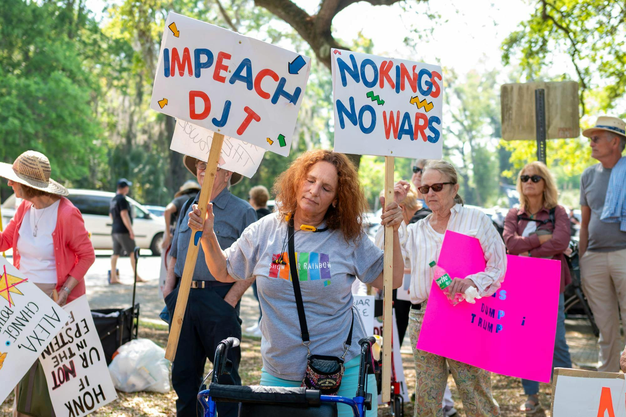 Protestors dance and hold signs at Cora Robertson Park, Saturday, March 28, 2026, in Gainesville, Fla.