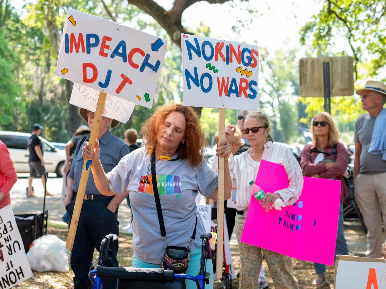 Protestors dance and hold signs at Cora Robertson Park, Saturday, March 28, 2026, in Gainesville, Fla.