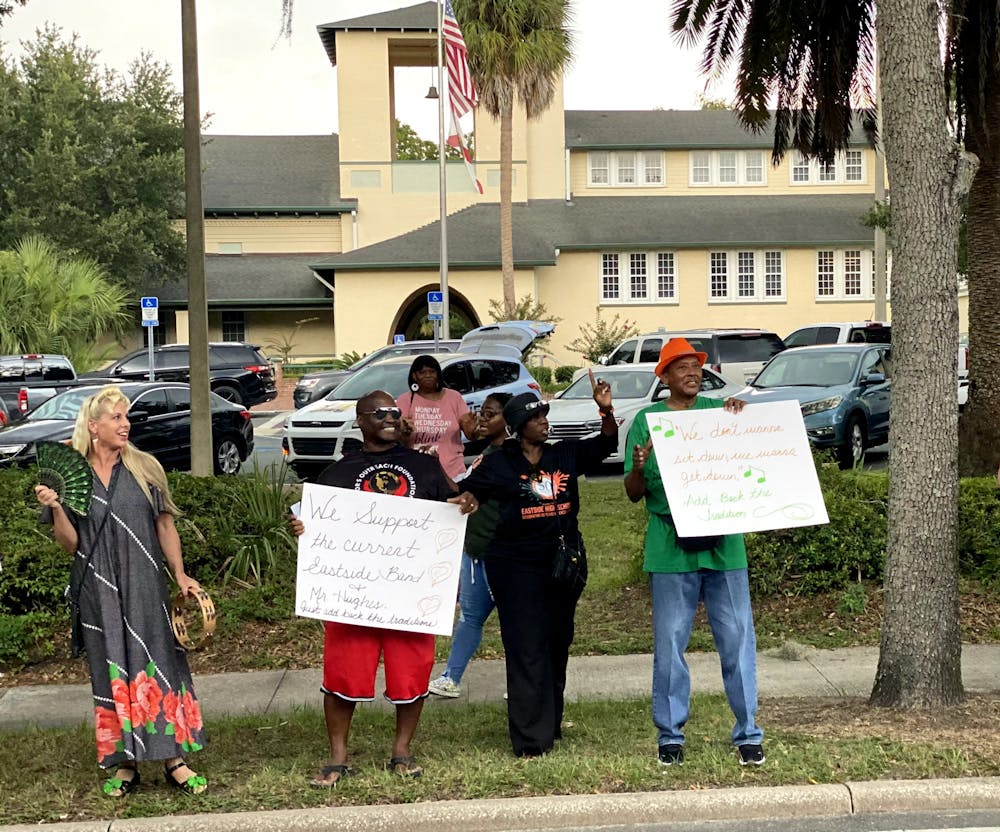 Demonstrators hold signs outside of Alachua County Public Schools Administration Building Tuesday, Aug. 16, 2022.