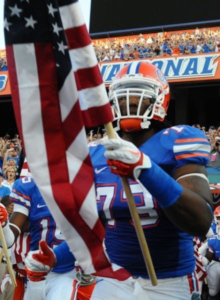 Gators offensive lineman Xavier Nixon, whose parents both have military backgrounds, was one of eight players to carry a flag on Saturday.