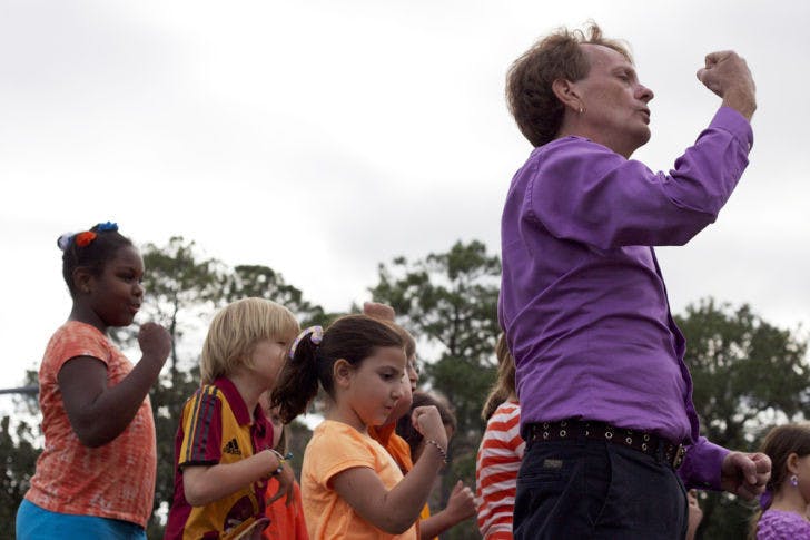 Expressions Learning Arts Academy drama teacher Scot Davis stands with elementary school students at the Unity Day March and Vigil for Peace on Tuesday afternoon. The event, which started at the corner of University Avenue and 13th Street, advocated against bullying and domestic violence.