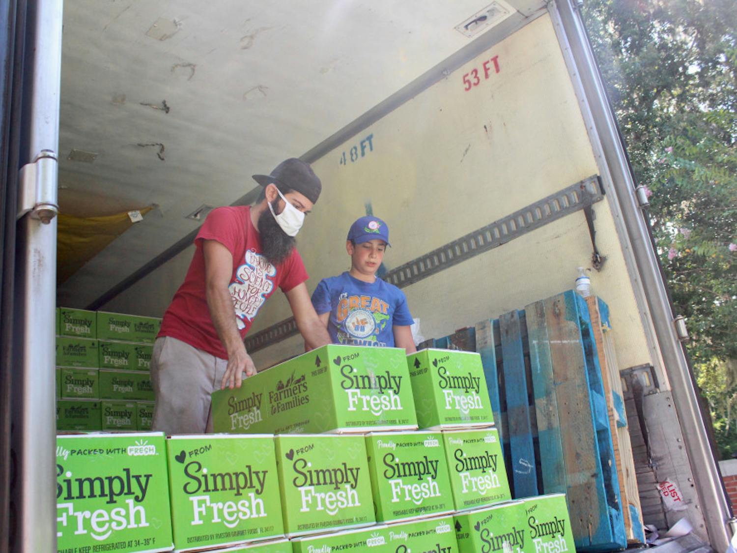Volunteers help unload pallets full of food boxes. The food was received from the Farmers to Families Food Box initiative under the USDA, part of the Families First Coronavirus Response Act, and helps get free, fresh and local food on people’s tables. They had 750 boxes of fruits and vegetables to give away.  