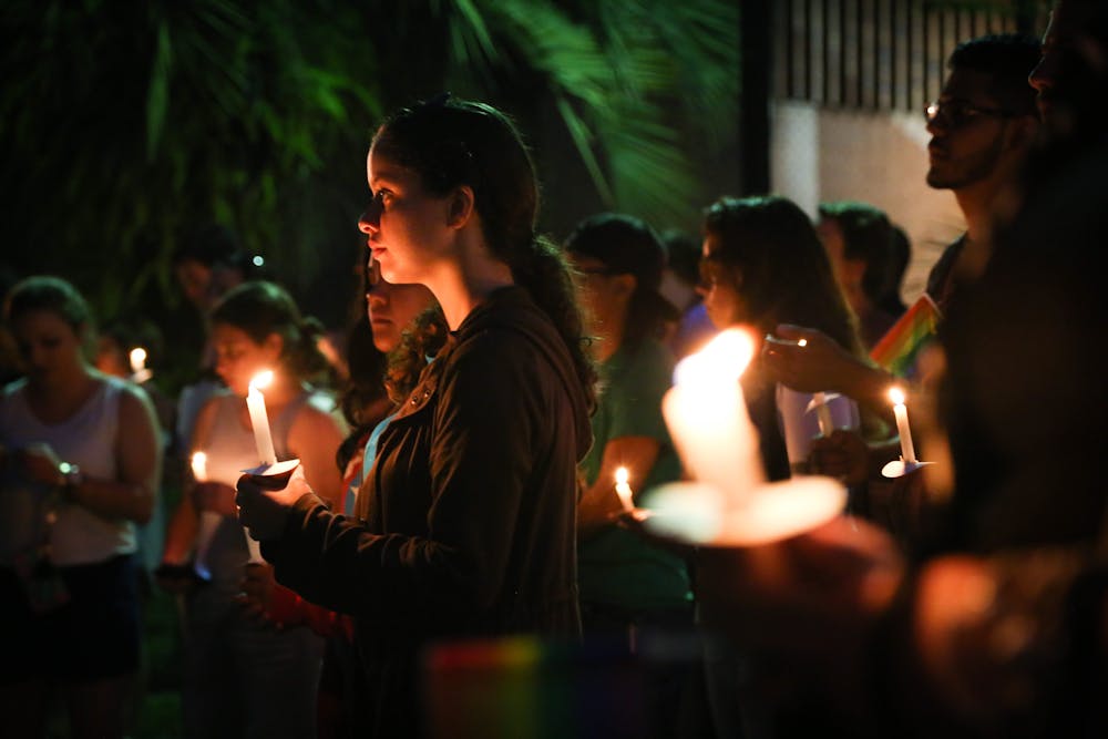 <p>Frances Patala, a 20-year-old UF animal sciences senior, listens to the speeches made on Tuesday evening at the Pulse Commemoration and Unity Ceremony. About 650 people came to the event, which included seven speakers and a candlelight vigil.</p>