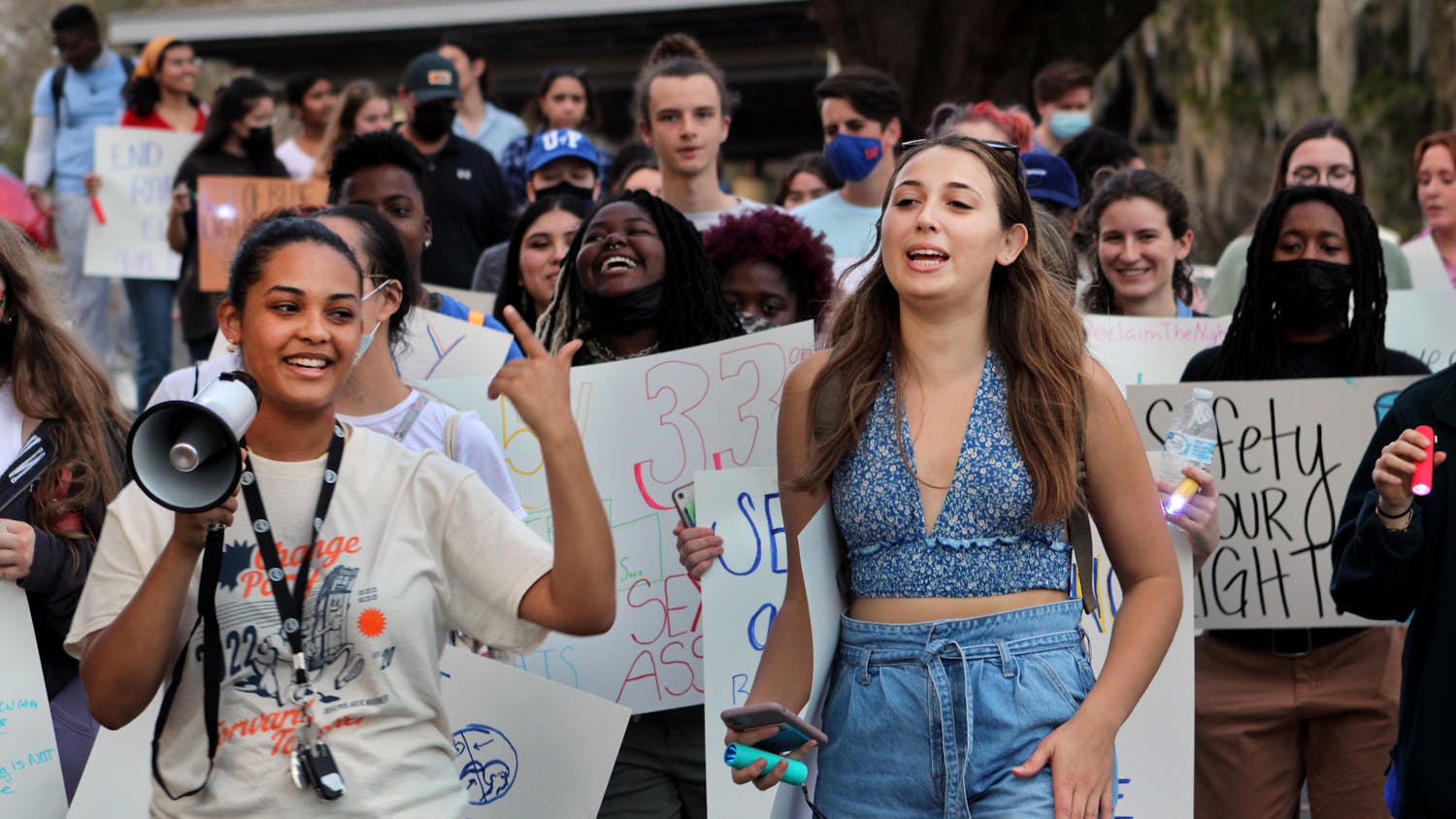 Gabrielle Adekunle (left), Change Party's presidential nominee, and Alexandra Quintana lead protestors down Fraternity Row on Friday, Feb. 4. The rally was held by Change Party to advocate for more emergency blue lights along Fraternity Row.