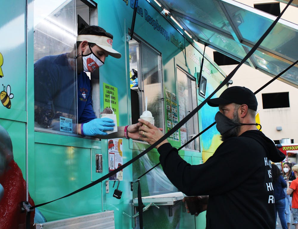 Gainesville resident Jon DeCarmine, 42, picks up gelato from the BZ Gelati Food Truck at the Original Gainesville Food Truck Rally hosted by High Dive on Saturday, Jan. 30, 2021.