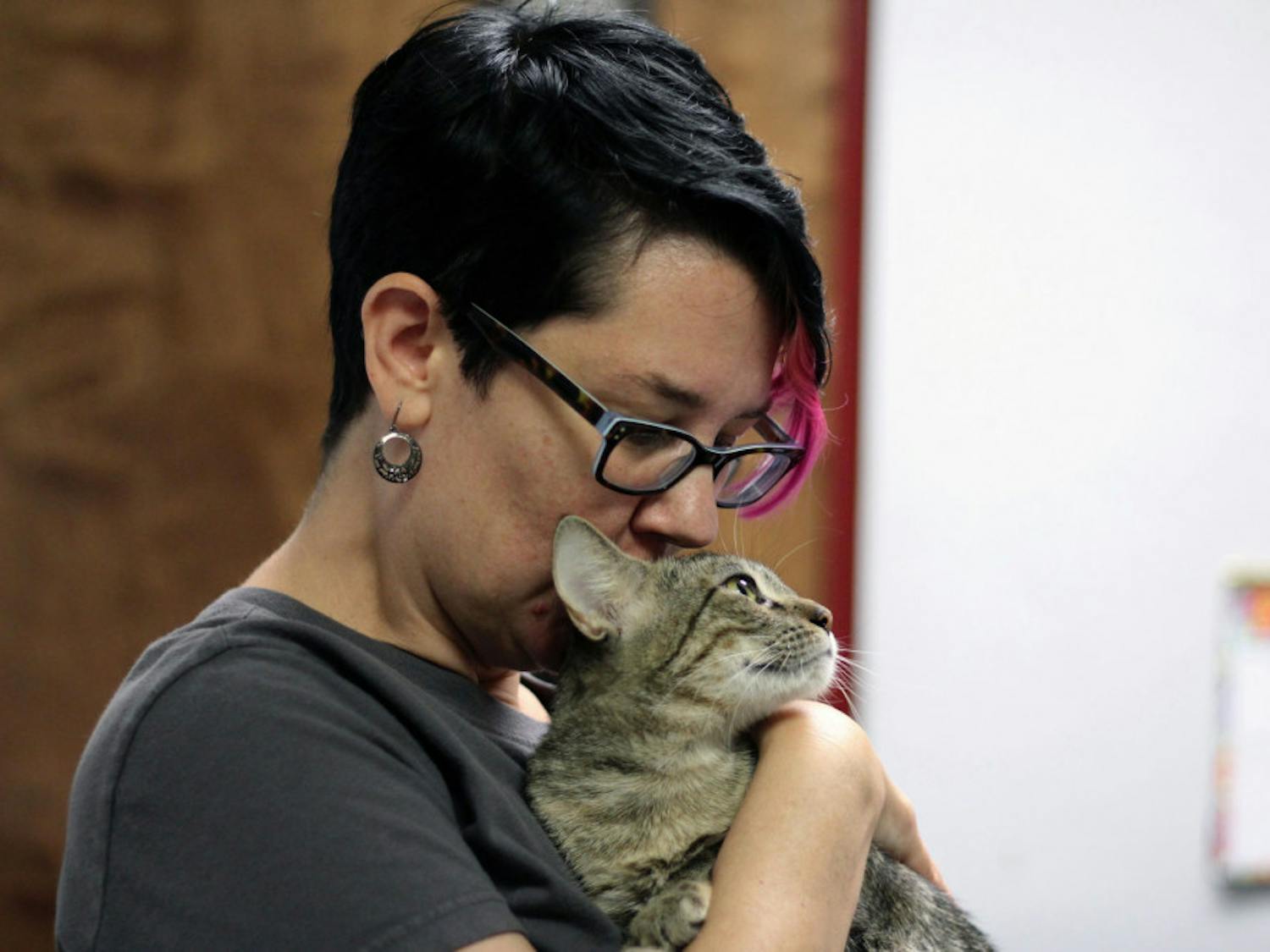 Gainesville resident Amber Young-Parker, 44, holds her new foster cat, Carmilla, at the Alachua County Humane Society. Young-Parker is fostering the cat for two weeks to help the shelter before Hurricane Irma.