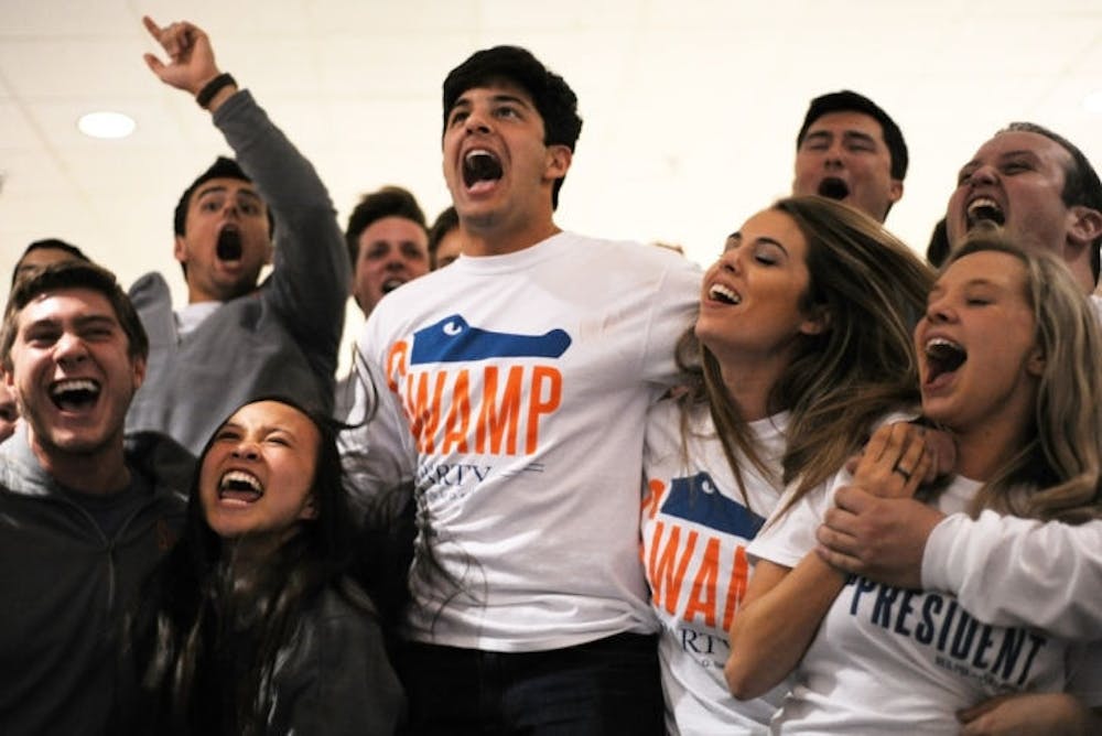 <p>Elliot Grasso, Vivan Nguyen and Cory Yeffet celebrate their executive ticket win as well as their party’s total sweep in Senate on Wednesday evening at the Reitz Union breezeway.</p>