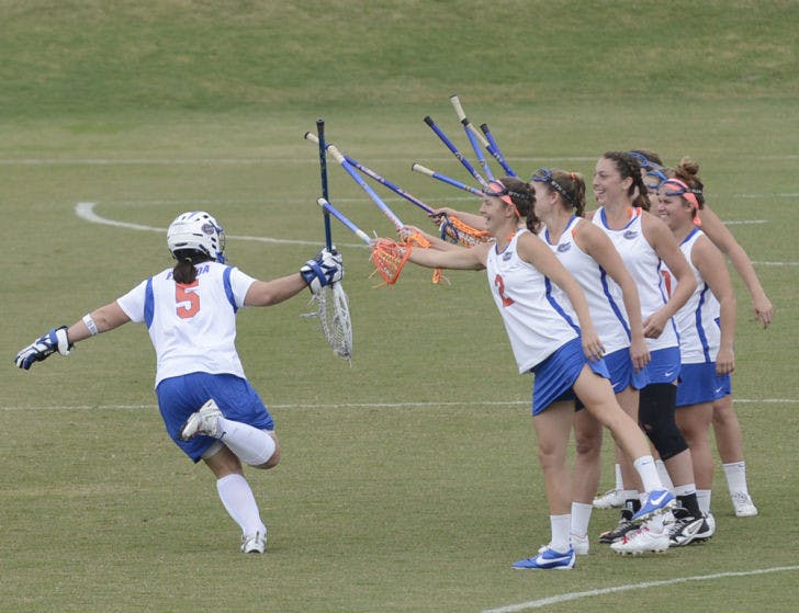 Mikey Meagher (5) joins her teammates on the field during player introductions before UF’s game against Ohio State on March 23. Meagher is preparing to play on the artificial surface of the Syracuse Carrier Dome on Saturday.